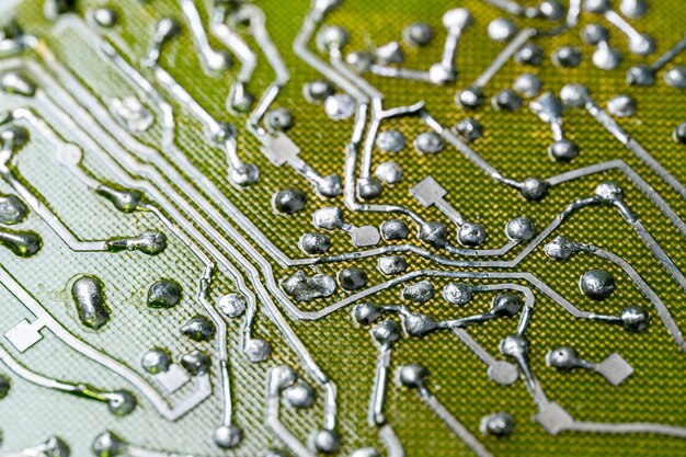 A close-up of a microchip on a circuit board, highlighting the complexity and technological advancement that fuels economic growth in the tech industry and beyond, set against a blurred background of other components.