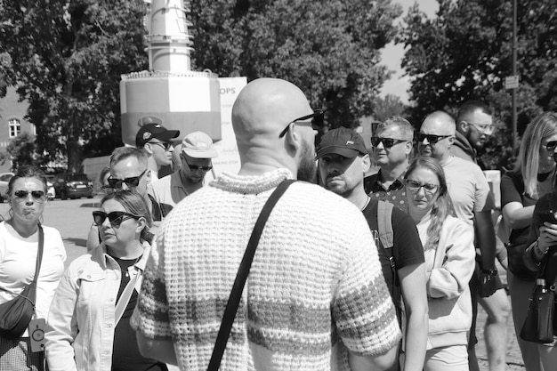 An old black and white photograph showing a historical event, people gathered around a speaker, capturing the atmosphere and moment in time.